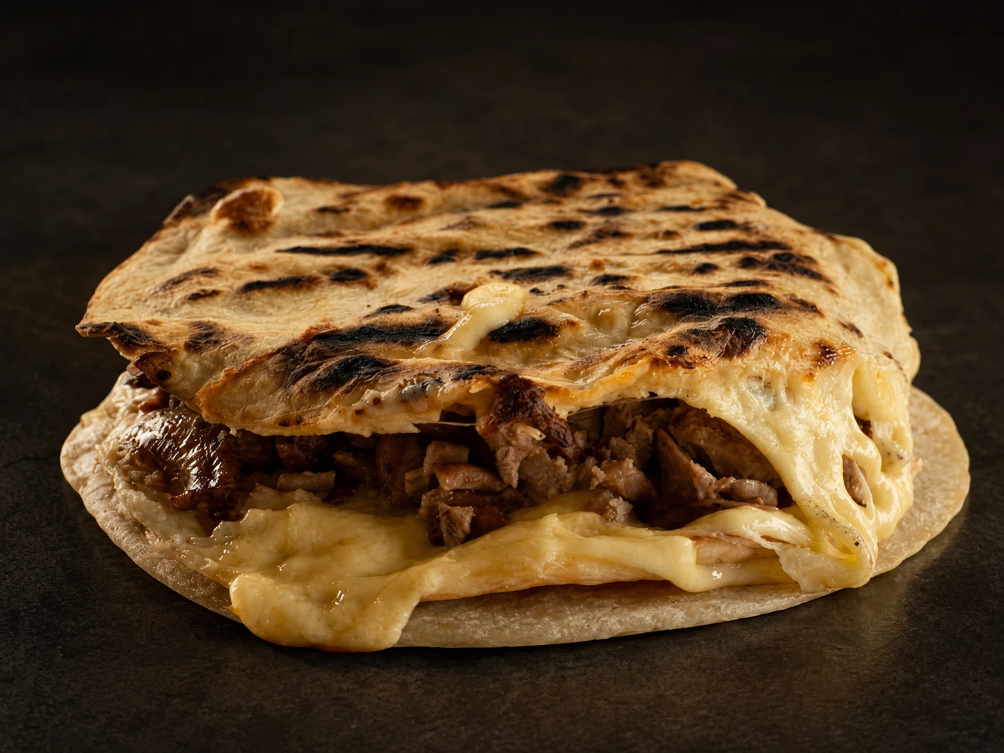 Plana de maíz de Taquería El Fili con carne y queso gratinado